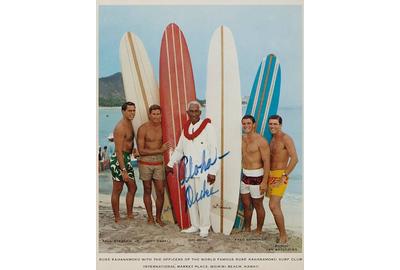 KAHANAMOKU, DUKE PAOA.  Photolithograph Signed ("Aloha - Duke"), 1960s, showing The Duke with the Officers of his Surf Club on Waikiki Beach.  This image was used for a Pan Am promotional flyer.  Estimate: $1,500 - 2,500 