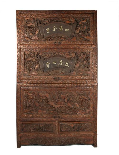 Chinese huanghuali lotus cabinet, elaborately carved all over in three-dimensional designs.  The three top doors lift up and slide in, and there are two drawers underneath (est.  $2,000-$4,000).