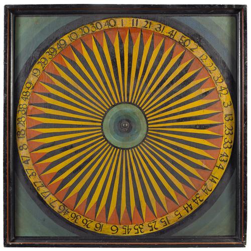 A rare large-size carnival gaming wheel made of eastern pine with polychrome paint decoration.  Excellent condition, missing the spinning arm and posts, paint is in untouched original condition.  The visual effect of the compass star, along with the vibrant colors, makes this piece a true work of art.  Originally found in the Berkshires, Massachusetts.  New England, circa 1900.  Courtesy of Tillou Gallery.