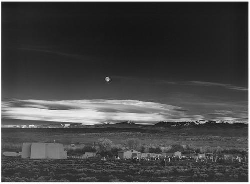 Moonrise, Hernandez, New Mexico shows a nighttime moon over a cloud-fringed mountain range with a graveyard in the foreground.  (Ansel Adams, Ansel Adams Publishing Rights Trust / September 17, 2007)