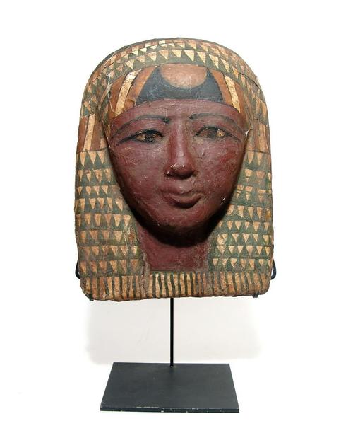 Egyptian painted cartonnage funerary mask (Late Period, circa 664-332 BC), face having a deep red skin tone and with black detailing to the eyes and brow (est.  6,000-$9,000).